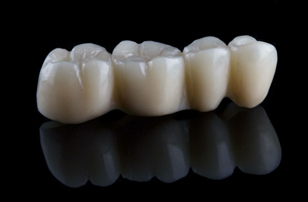 A close-up of a zirconium dental bridge on a reflective surface.