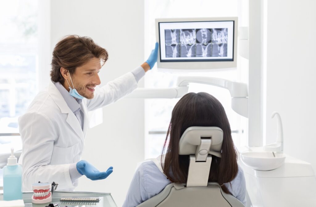 Dentist showing a patient images from their dental x-rays and carefully explaining the results.